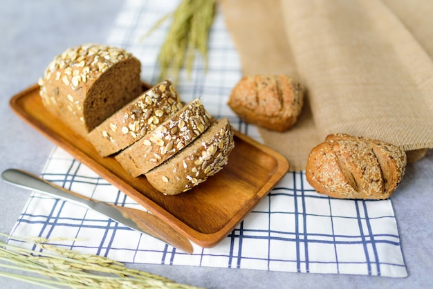 Homemade Whole Wheat Rye Bread Loaf is cut and placed on a wooden plate.And put on a tablecloth.