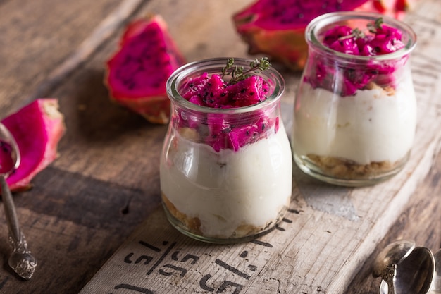 Homemade yoghurt with Ripe Dragon fruit, Pitaya or Pitahaya on wooden background, fruit healthy concept