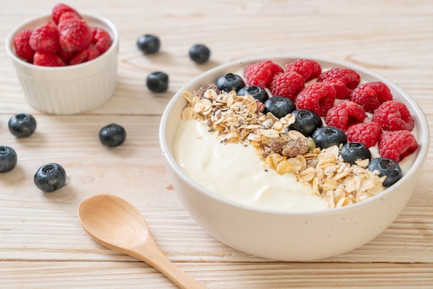 homemade yogurt bowl with raspberry, blueberry and granola  - healthy food style