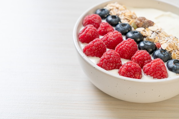 homemade yogurt bowl with raspberry, blueberry and granola  - healthy food style