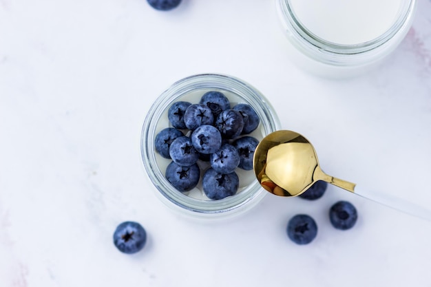 Homemade yogurt with blueberries Top view on the white table