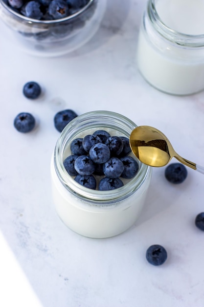 Homemade yogurt with blueberries Top view on the white table