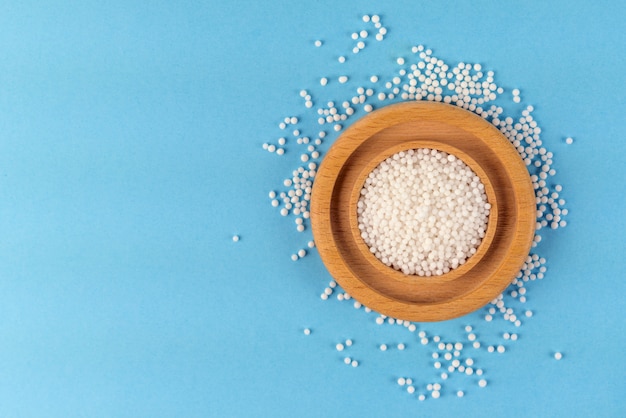 Homeopathic grains on a wooden plate scattered on the table