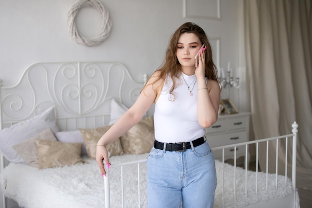 A homeschooled student Standing with a phone in a white room