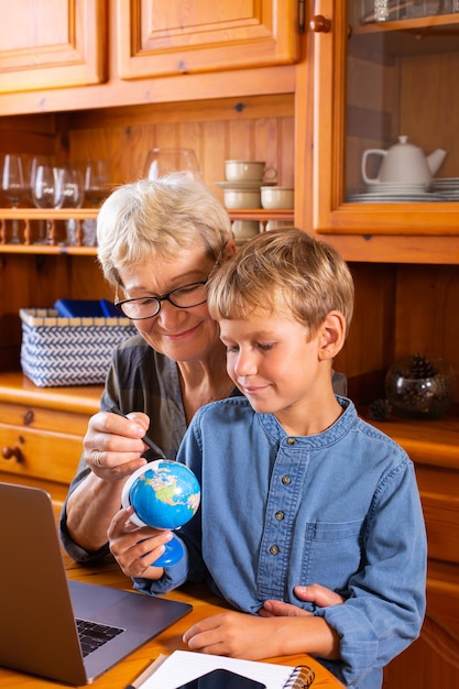 Homeschooling grandmother teaching smart boy child in geography