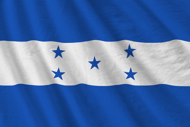 Honduras flag with big folds waving close up under the studio light indoors The official symbols and colors in banner