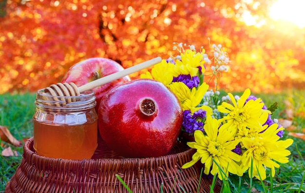 Honey apple and pomegranate on wooden table over bokeh background