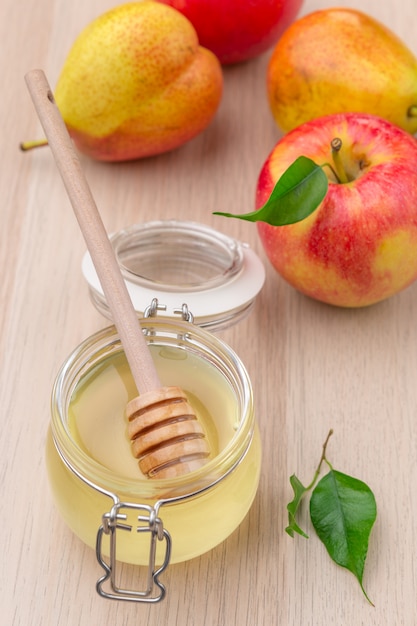 Honey and apples on wooden table