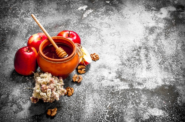 Honey background. Fragrant honey in a pot with apples and herbs.