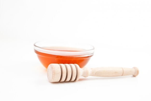 Photo honey bowl behind a honey dipper