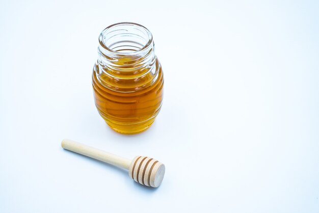 Honey jar, honey and honeycomb on the white background