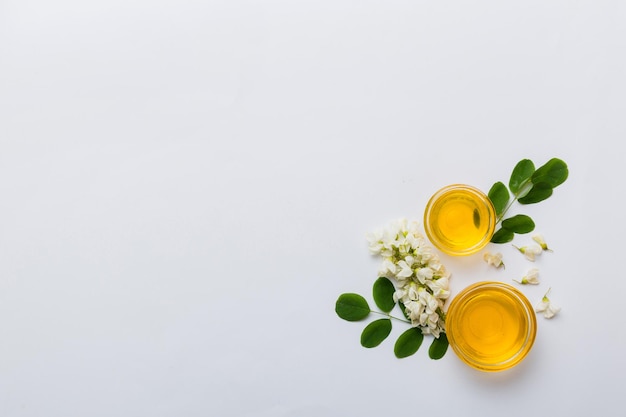 Honey jar with acacia flowers and leaves fresh honey top view flat lay