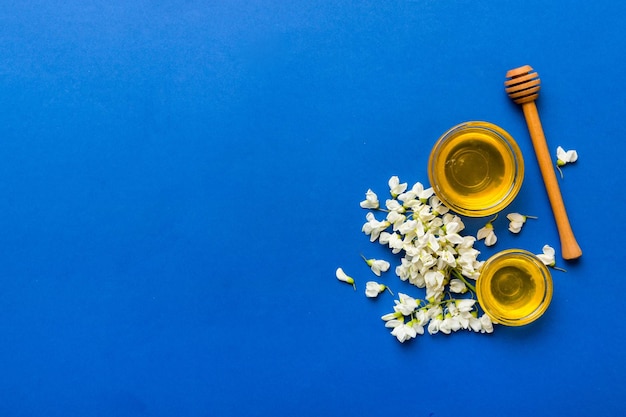 Honey jar with acacia flowers and leaves fresh honey top view flat lay