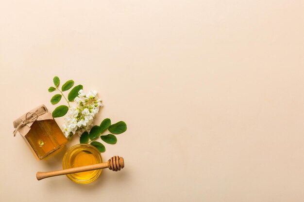 Honey jar with acacia flowers and leaves fresh honey top view flat lay