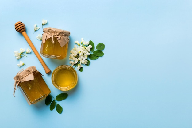 Honey jar with acacia flowers and leaves fresh honey top view flat lay