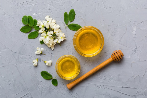 Honey jar with acacia flowers and leaves fresh honey top view flat lay