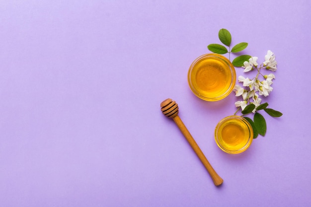 Honey jar with acacia flowers and leaves fresh honey top view flat lay