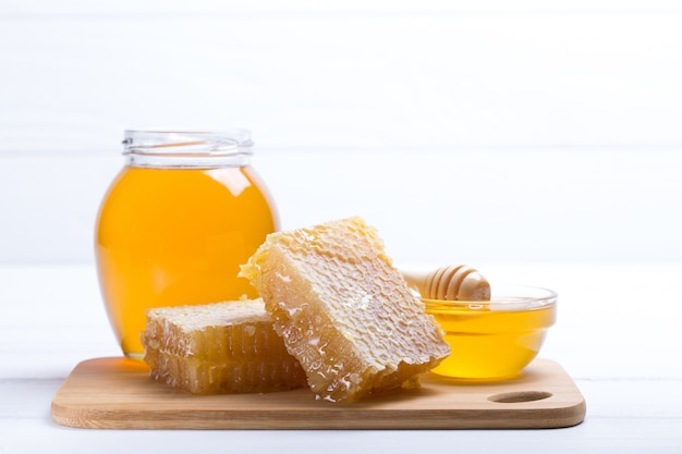 Honey in jar with honey dipper on wooden background