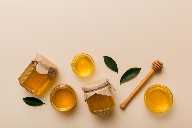 Honey jar with wooden honey dipper on white background top view with copy space Delicious honey bottle