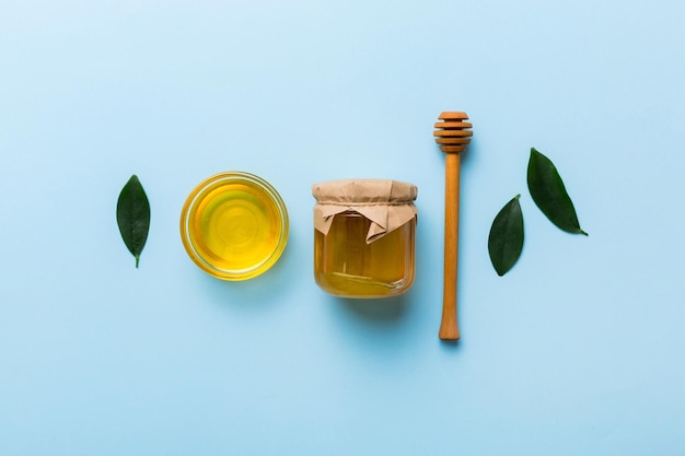 Honey jar with wooden honey dipper on white background top view with copy space Delicious honey bottle