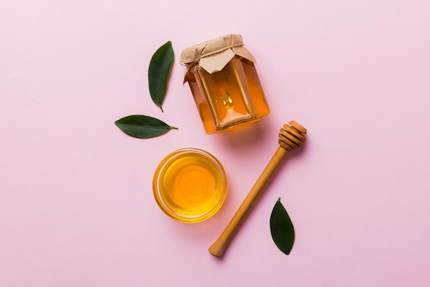 Honey jar with wooden honey dipper on white background top view with copy space Delicious honey bottle