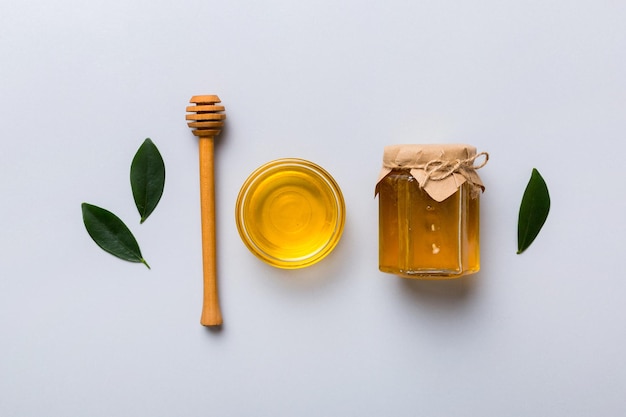 Honey jar with wooden honey dipper on white background top view with copy space Delicious honey bottle