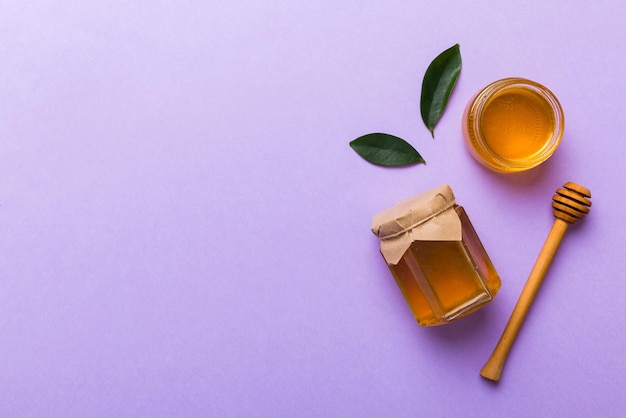 Honey jar with wooden honey dipper on white background top view with copy space Delicious honey bottle