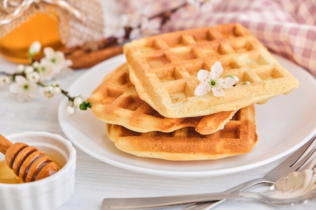 Honey pouring on a fresh Belgian waffles