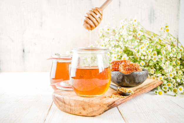 Honey in small jar with pollen and honey combs