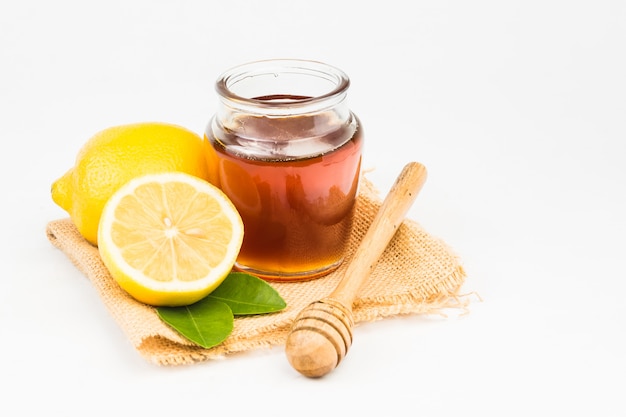 Honey with lemon on white background 