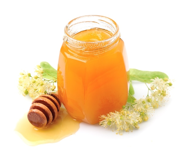 Honey with linden flowers isolatewd on white.