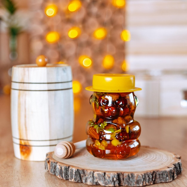 honey with nuts and fruits dripping from a jar in a christmas new year interior on a wooden table