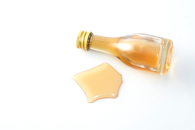 Honey wooden dipper and little honey bottle on white 