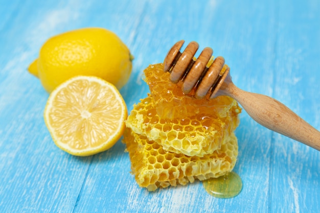 Honeycombs and lemon lie on a blue wooden .