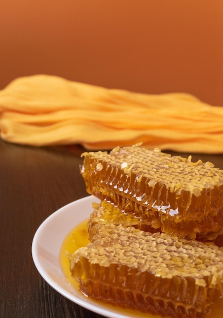 Honeycombs in white plate on the wooden table. Natural organic bee product. Healthy lifestyle.