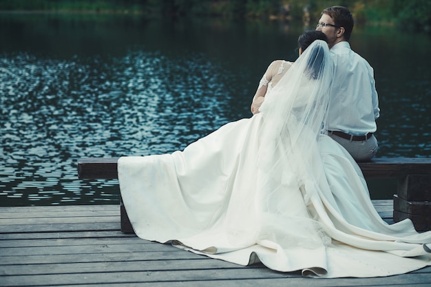 Honeymoon. The bride and groom hugging on the shore of Lake.