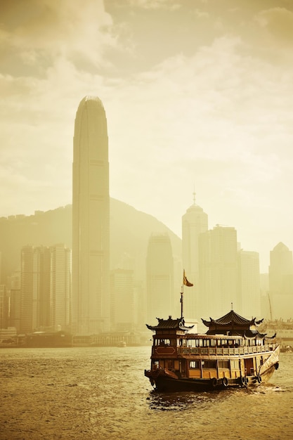 Hong Kong skyline with boats in Victoria Harbor in yellow tone.