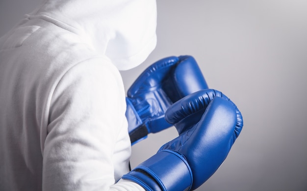 Photo hooded man with a boxing gloves.