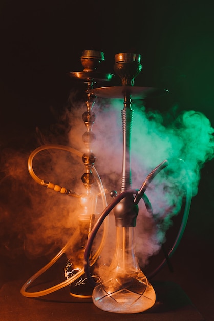 Hookahs on a smoky dark room with neon lighting and smoke