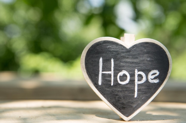 Photo hope inscription on the heart sharing hope concept green bokeh background