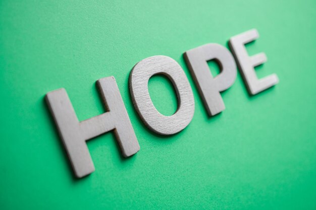 hope word with wooden letters on the green background