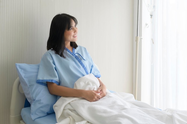 Hopeful and happy young patient woman in hospital healthcare and medical concept