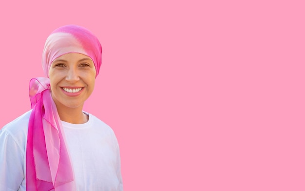 Hopeful woman wearing a headscarf on a pink background