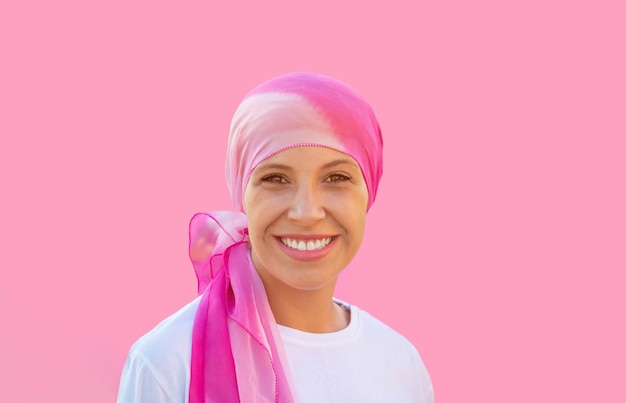 Hopeful woman wearing a headscarf on a pink background