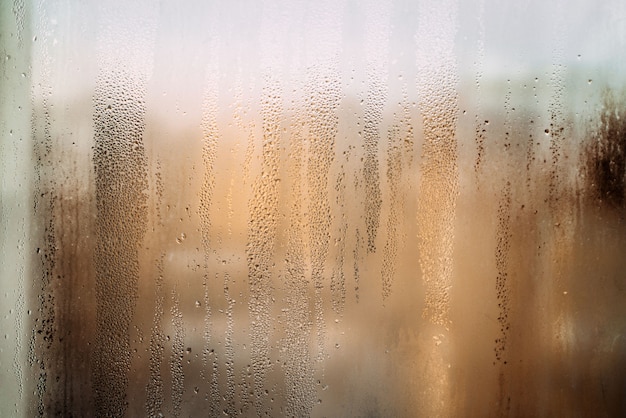 horizontal background texture of a wet window in drops with sun after rain warm photo high quality