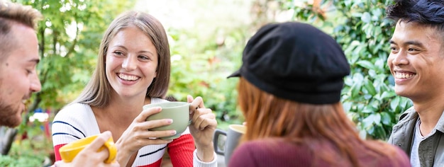 Horizontal banner or header with young people drinking cappuccino and espresso coffee at cafe bar garden Happy friends talking and having fun together at hostel dehors