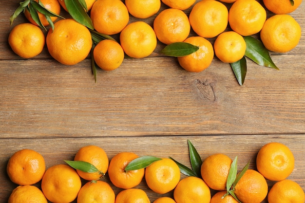 Horizontal frame made of tangerines on wooden background