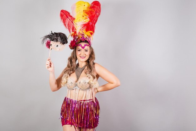 Horizontal half body shot beautiful Brazilian woman in carnival clothes holding carnival mask