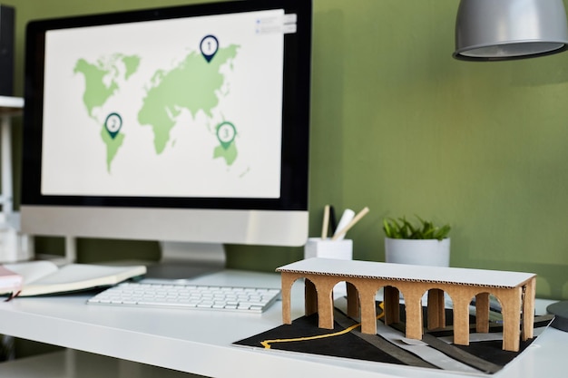 Horizontal image of construction mockup on table with computer monitor in background