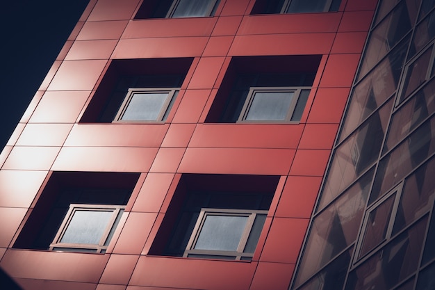 Horizontal image of the facade of a modern building with square windows and deep shadows filter